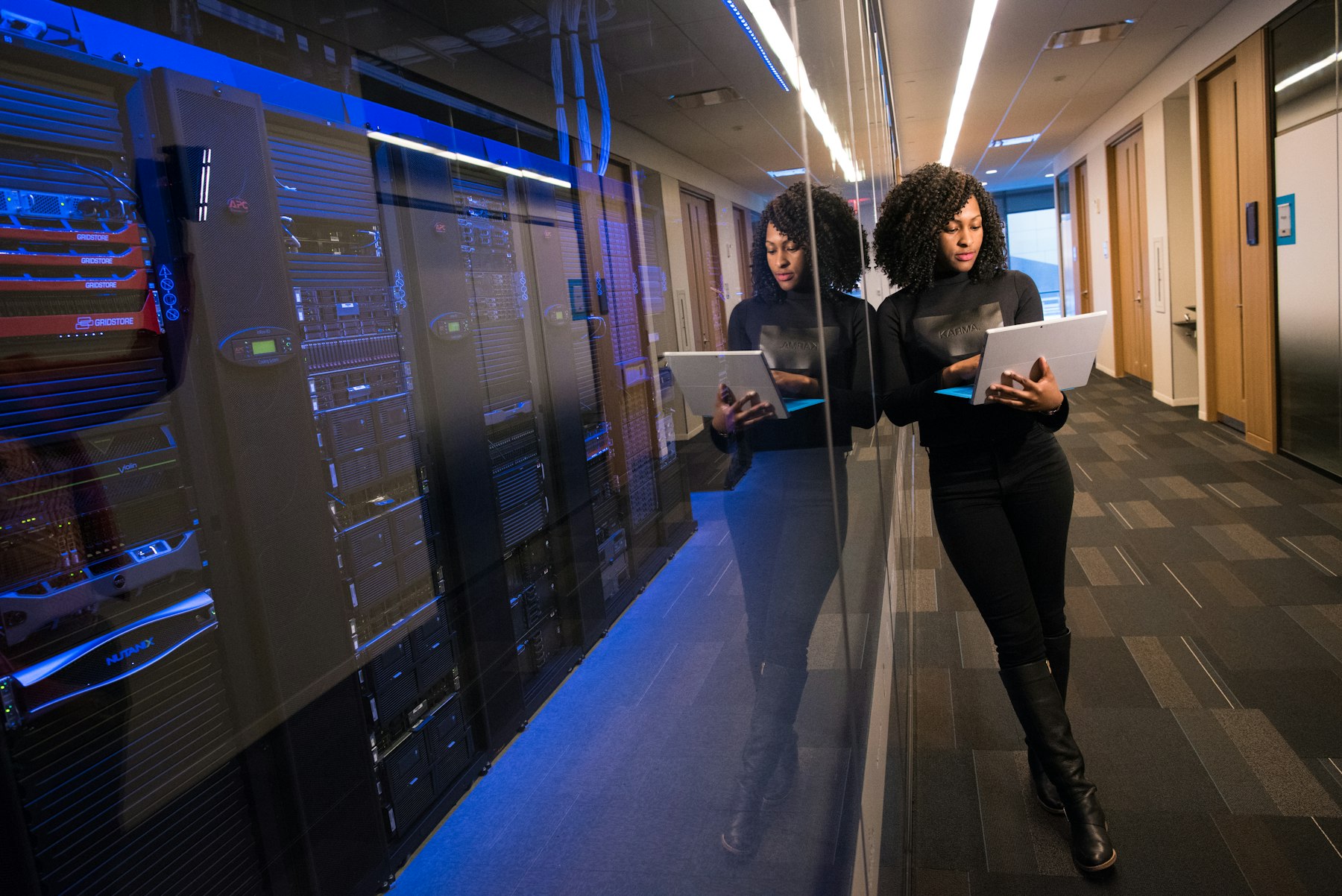 Two engineers walking through a data center corridor with a laptop